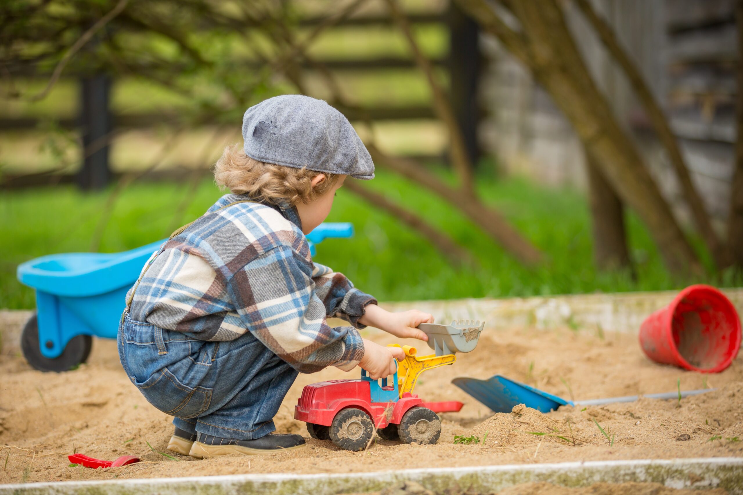 Small caucasian boy playing in sandpit. Handsome blonde 4 years boy in his sandbox.